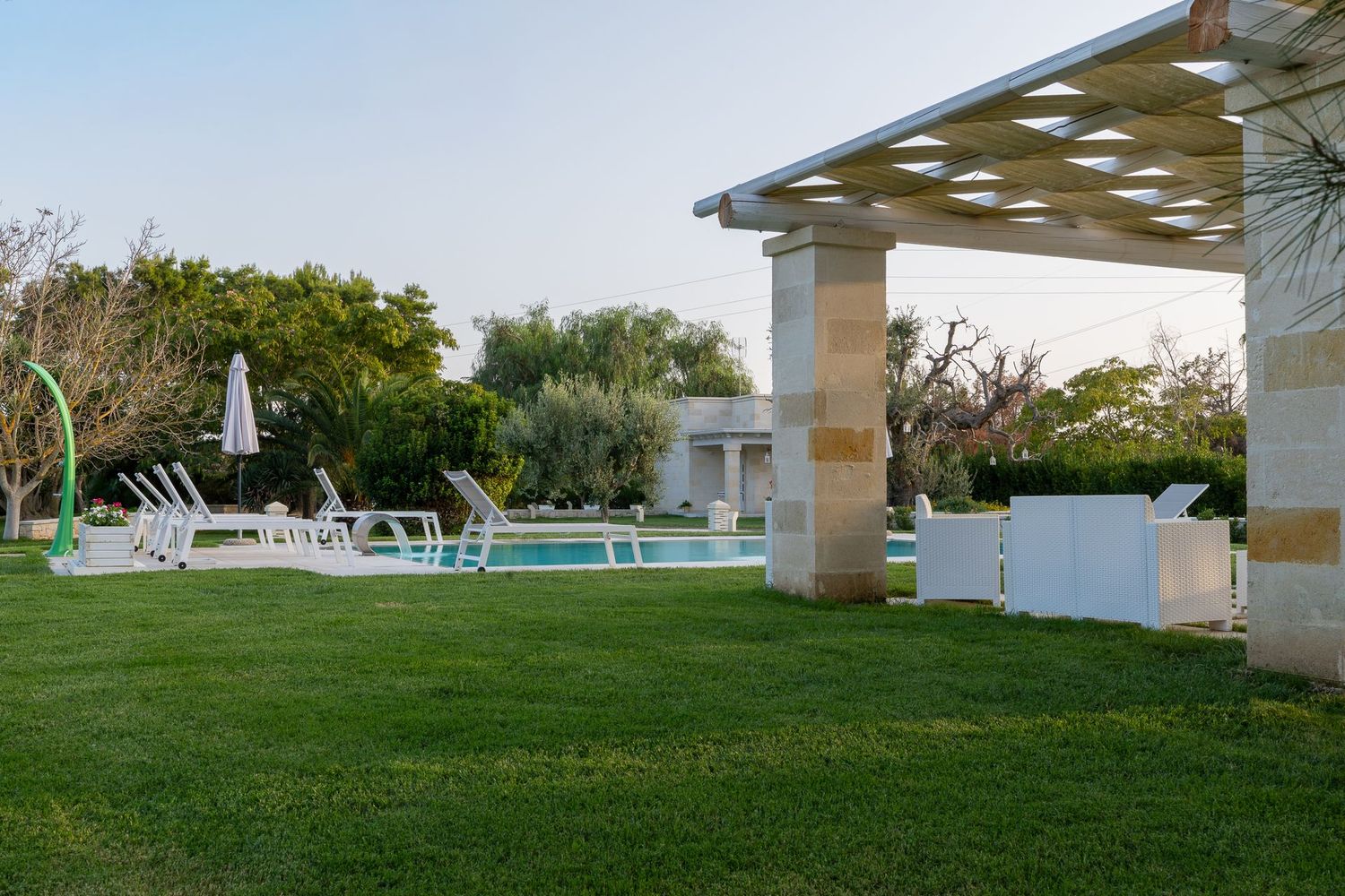 Gli esterni della Dimora: piscina di acqua salata, pietra e giardino